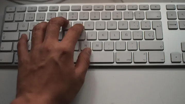 a hand typing on a keyboard